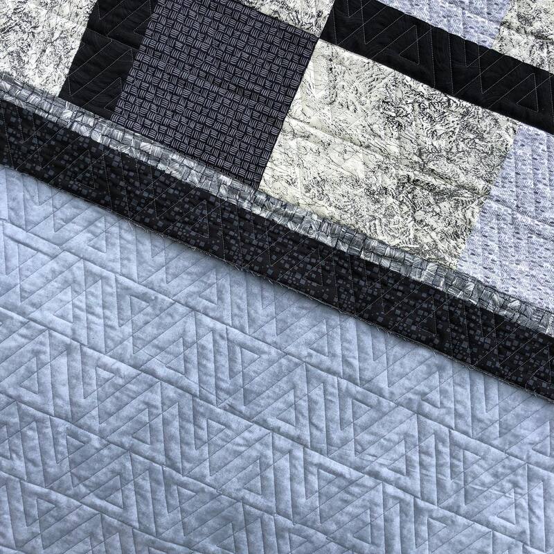 Modern triangles pantograph on a classic black and grey quilt, machine quilted by Amy Martin of Peaceful Quilts in Lafayette Indiana