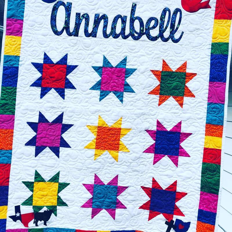 A custom quilt pieced by Amy Martin of Peaceful Quilts in Lafayette Indiana. Bright sawtooth stars with custom appliques designed and cut on a Cricut Explore Air 2.
