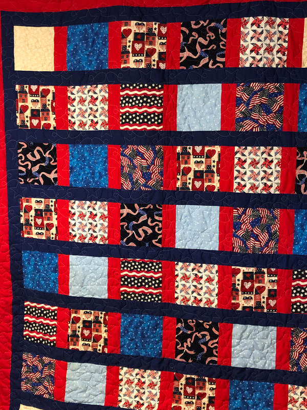A red, white, and blue patriotic quilt to honor a Vietnam veteran, machine quilted by Amy Martin of Peaceful Quilts in Lafayette Indiana