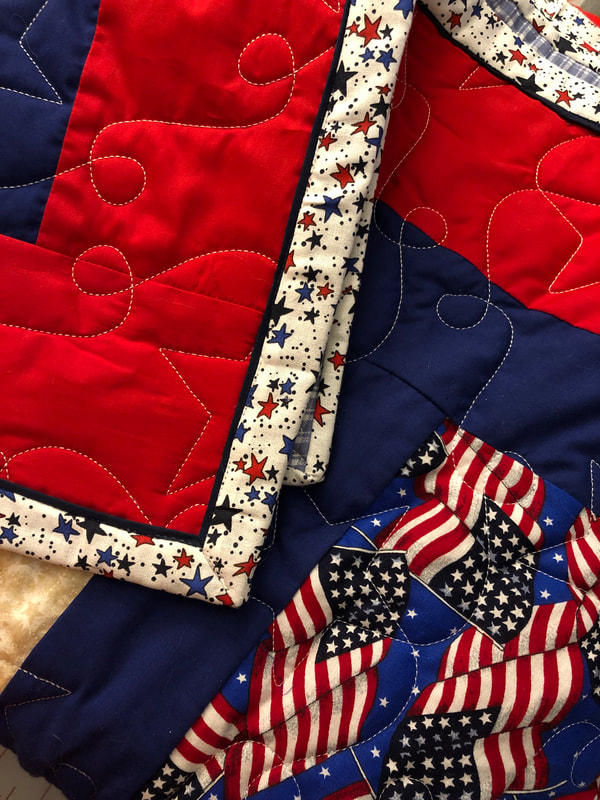 A flange binding on a patriotic quilt, machine quilted by Amy Martin of Peaceful Quilts in Lafayette Indiana