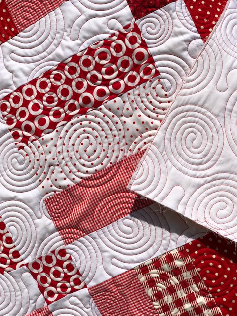 Red and white quilt with beautiful spirals, machine quilted by Amy Martin of Peaceful Quilts located in Lafayette Indiana. 